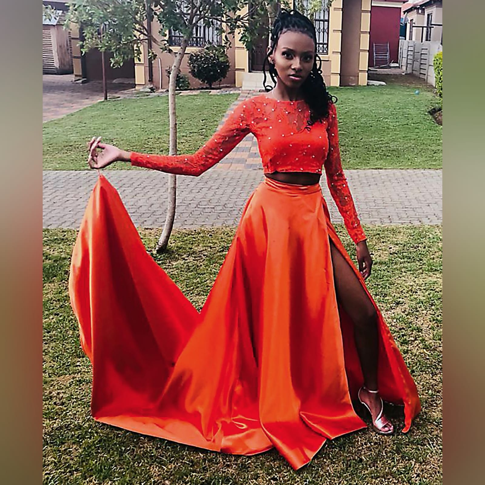 2 piece orange prom dress with a lace crop top 1 2 piece orange prom dress with a lace crop top detailed with silver beads. Flowy, shiny skirt with crossed slit and long train.