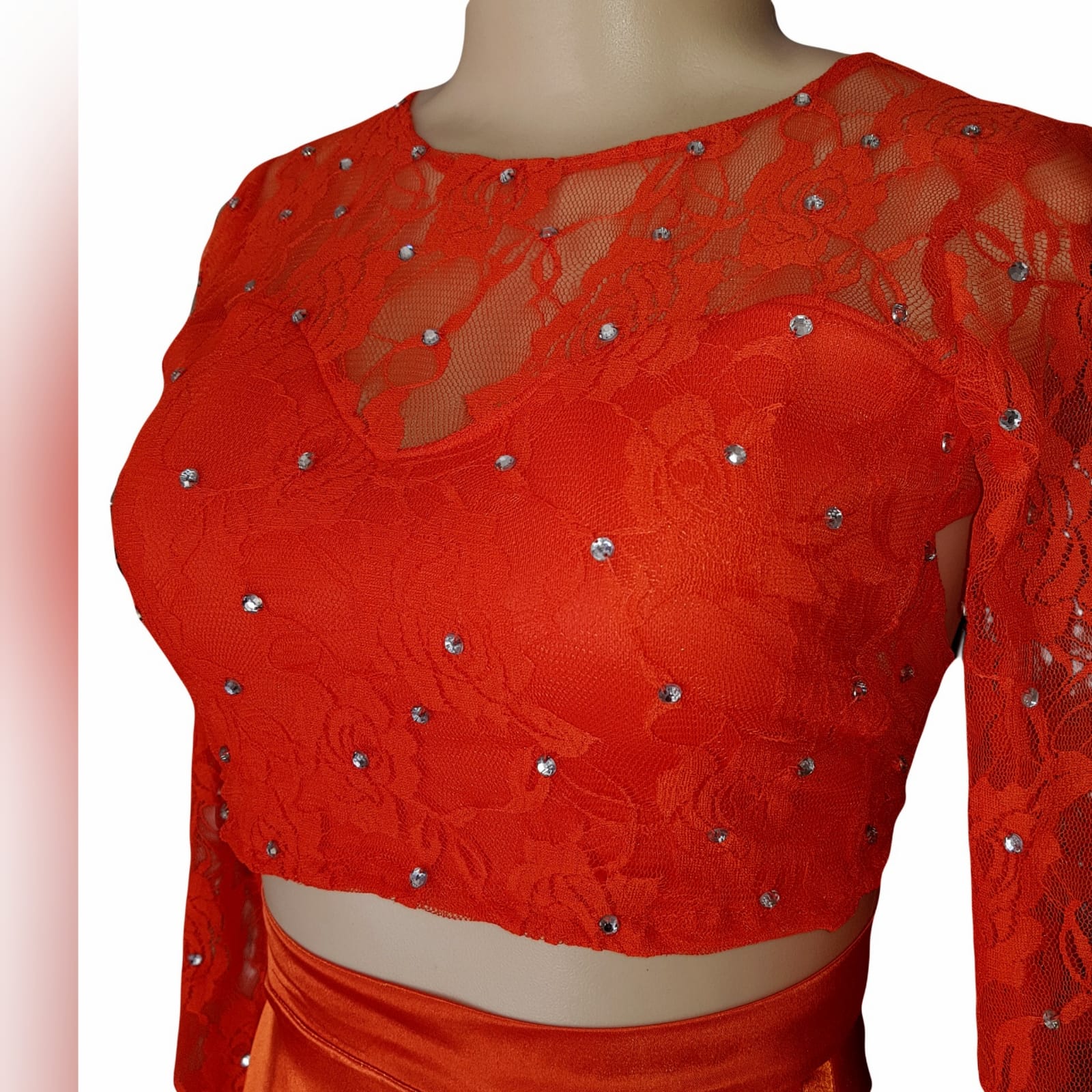 2 piece orange prom dress with a lace crop top 6 2 piece orange prom dress with a lace crop top detailed with silver beads. Flowy, shiny skirt with crossed slit and long train.