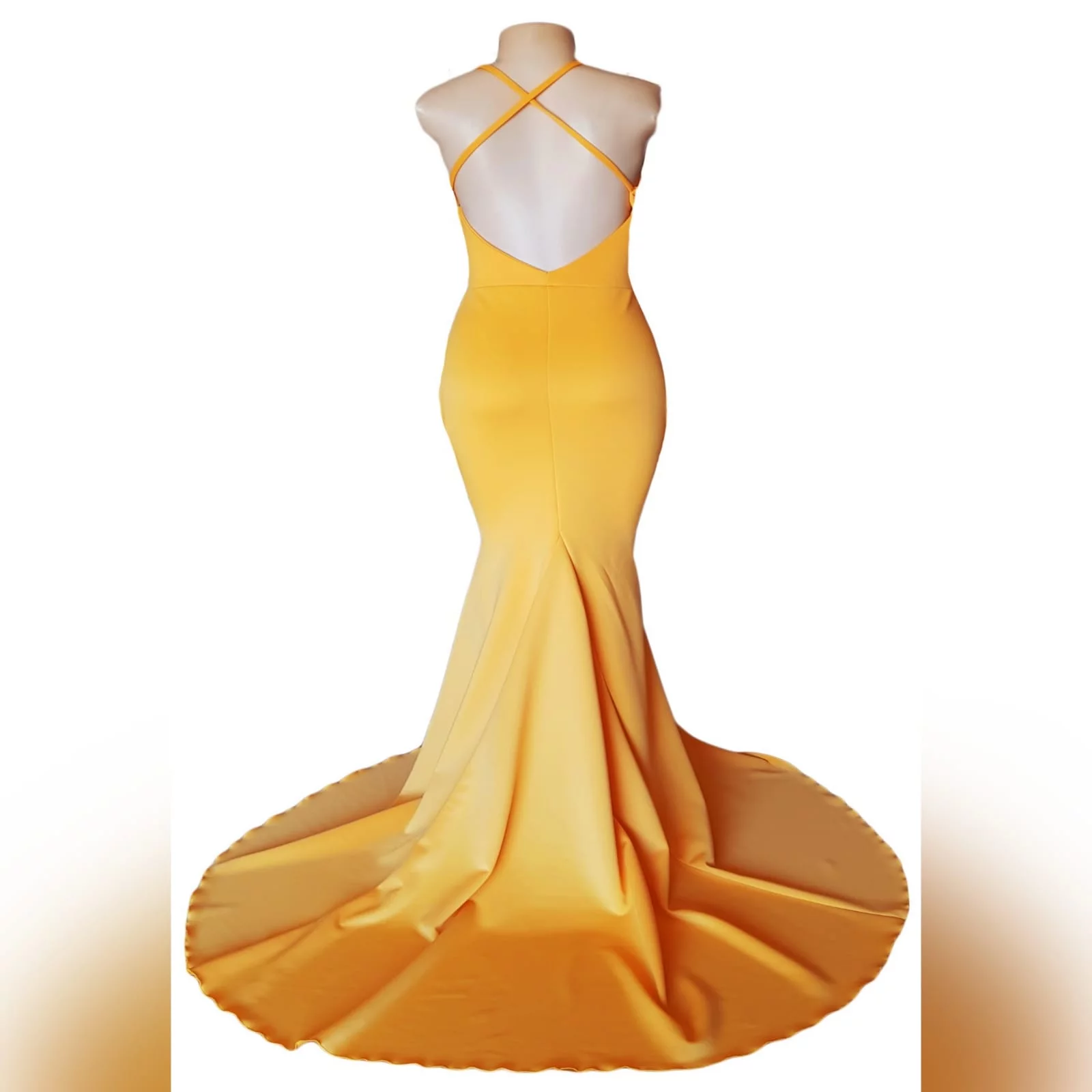 Vestido de finalistas amarelo sereia suave 7 vestido de finalistas amarelo sereia suave, com uma abertura de barriga de triângulo. Decote em v e costas abertas com alças finas cruzadas e uma cauda.