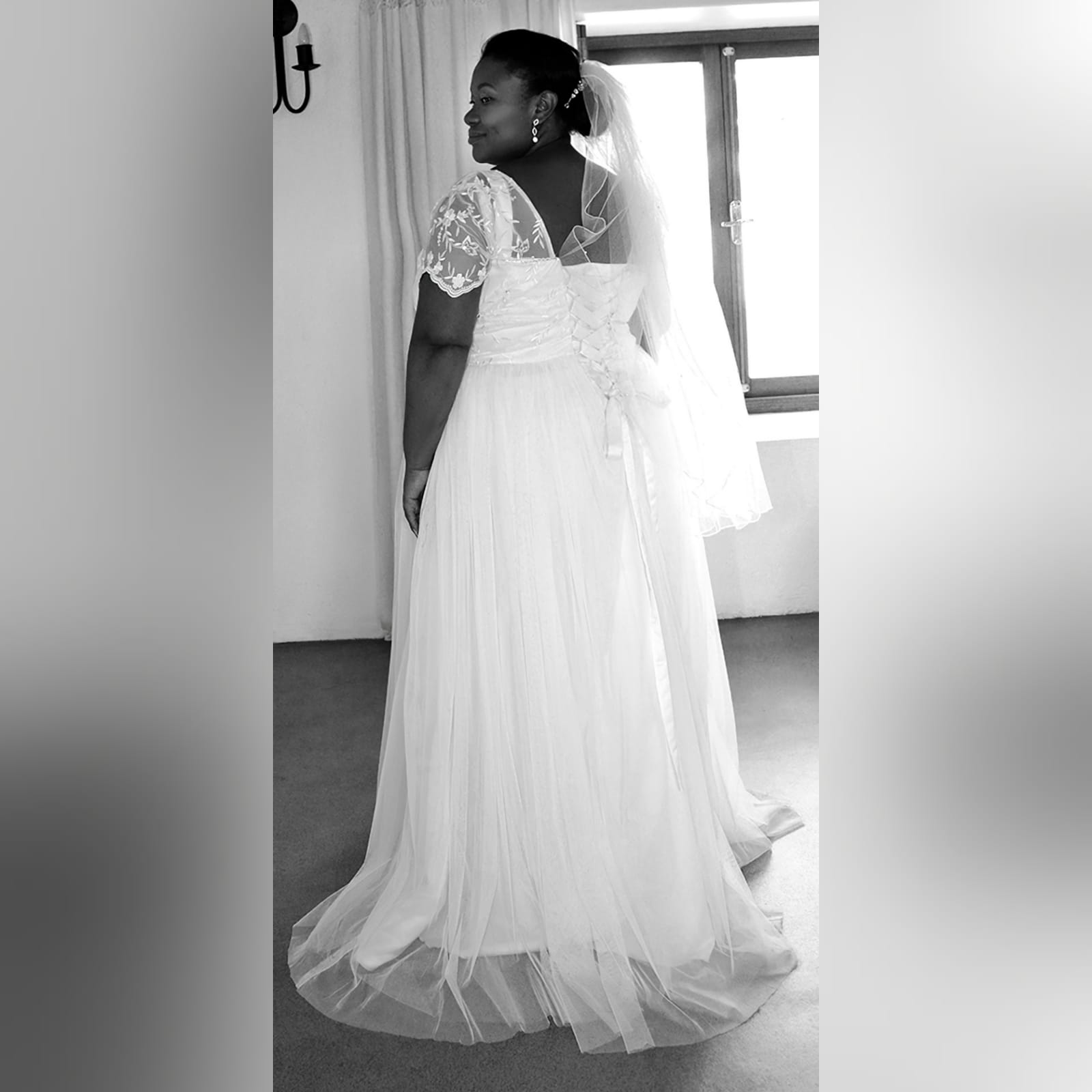 Plus size white tulle and lace wedding dress 1 white tulle and lace wedding dress. Bodice in lace with short sleeves and a lace up back. With a touch of silver beads.