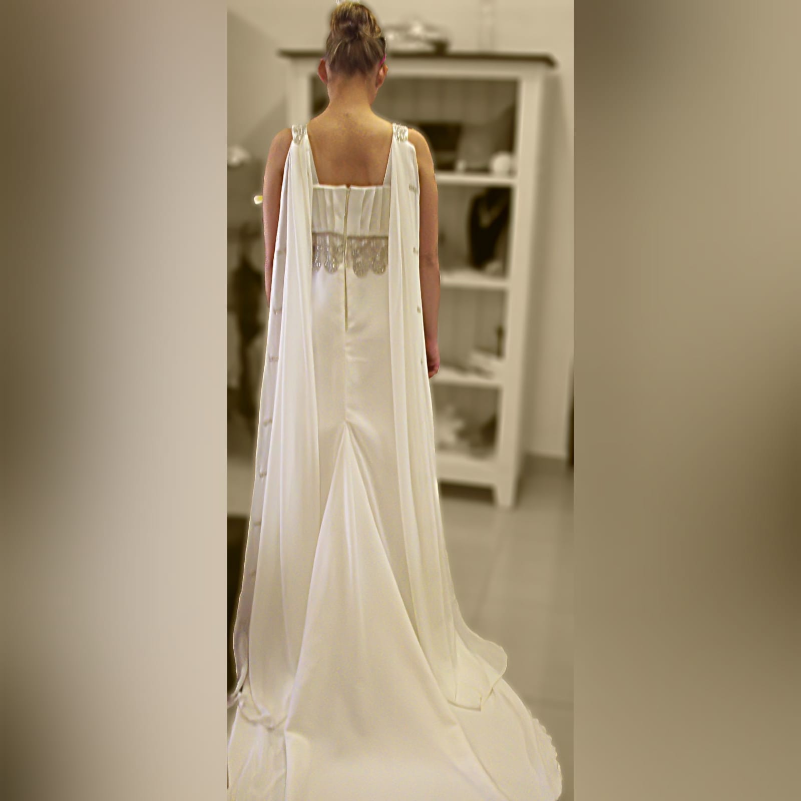 Ivory cross busted wedding dress with train 4 ivory cross busted wedding dress with an added back panel creating a train. Two long shoulder chiffon pieces decorated with bronze embroidery detail and under bust finish this wedding dress off.