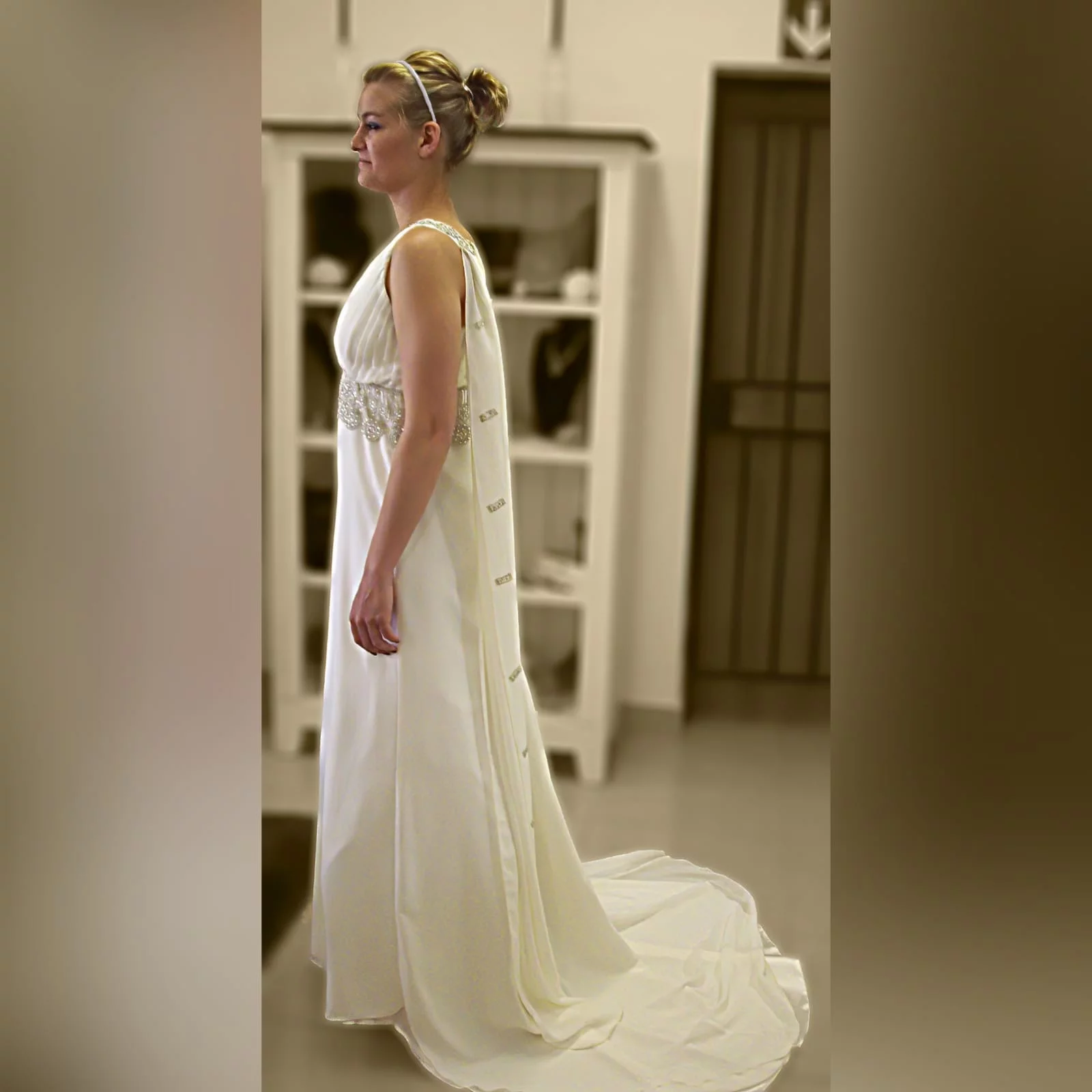 Ivory cross busted wedding dress with train 3 ivory cross busted wedding dress with an added back panel creating a train. Two long shoulder chiffon pieces decorated with bronze embroidery detail and under bust finish this wedding dress off.