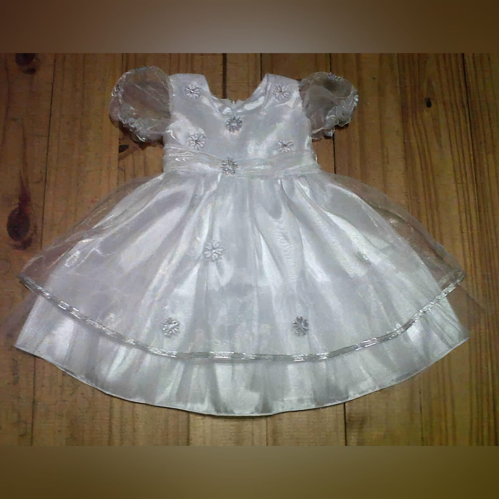 White baptism dress with silver details 2 white baptism dress made in satin with an organza overlay detailed with silver flowers and silver ribbon and short bubble sleeves.