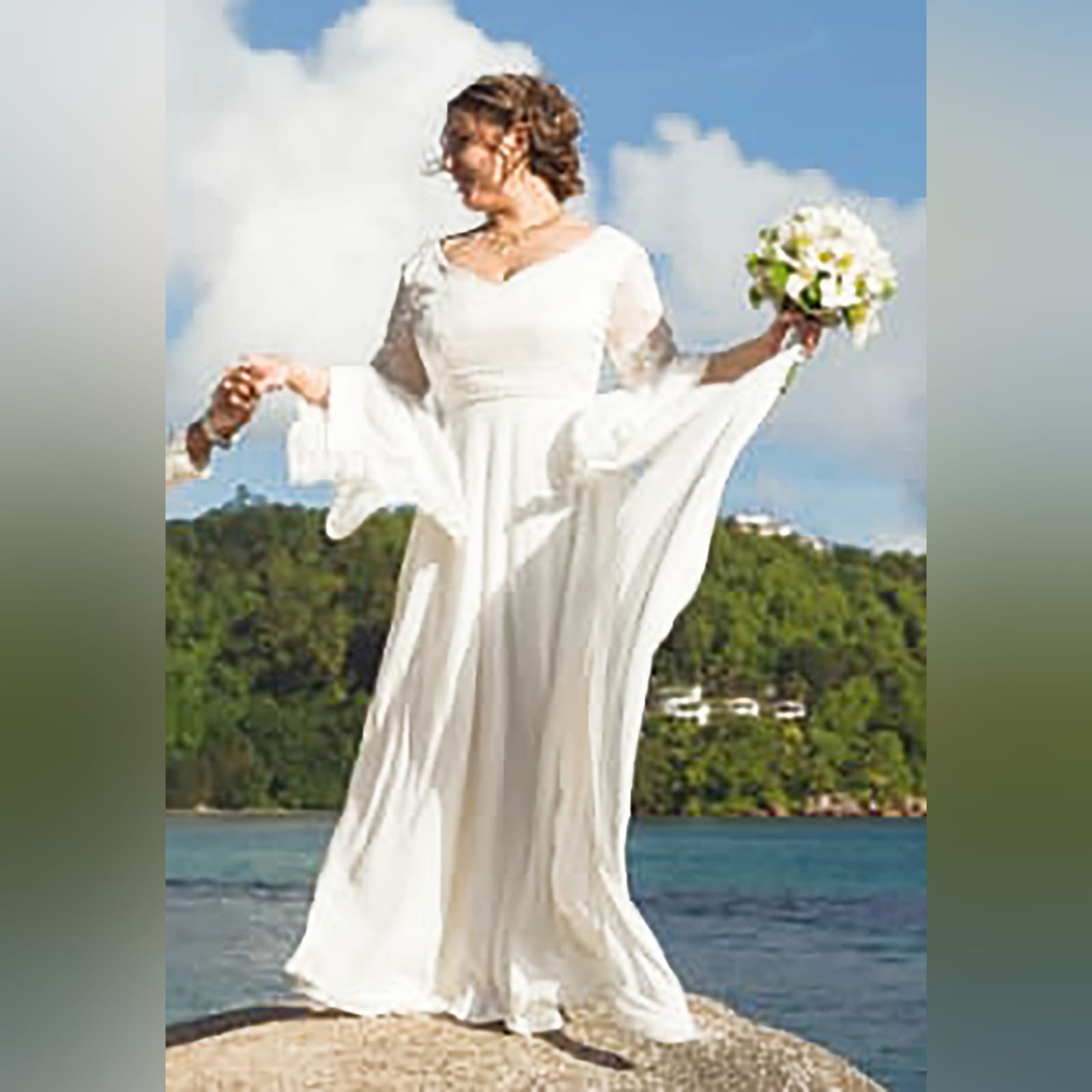 White flowy lace bodice wedding dress 1 white flowy lace bodice wedding dress. With bell sleeve and train. Sleeve and belt detailed with pearls. Stunnning wedding dress awesome for a beach wedding.