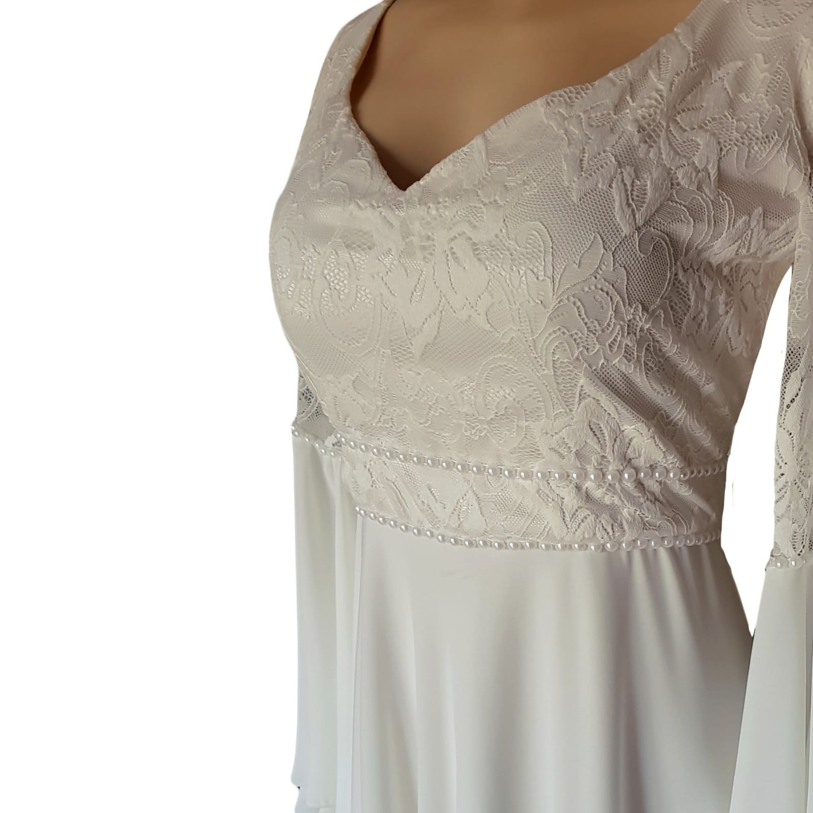 White flowy lace bodice wedding dress 8 white flowy lace bodice wedding dress. With bell sleeve and train. Sleeve and belt detailed with pearls. Stunnning wedding dress awesome for a beach wedding.