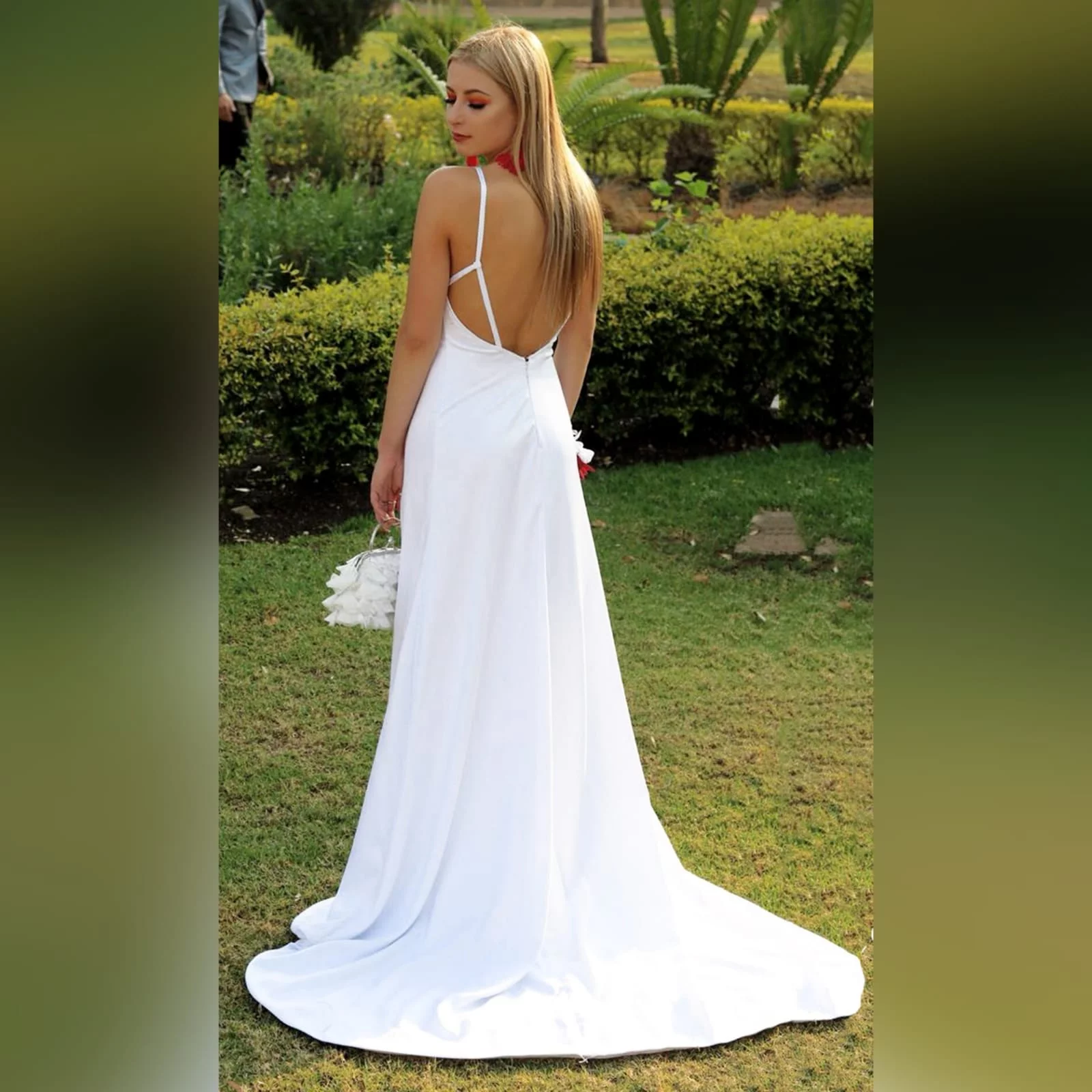White satin long prom dress with a low open back 1 white satin long prom dress with a low open back, with strap detail. Straight neckline, 2 slits and a train.