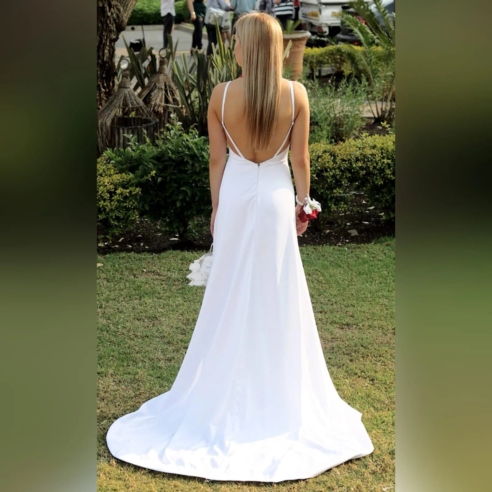 White satin long prom dress with a low open back 4 white satin long prom dress with a low open back, with strap detail. Straight neckline, 2 slits and a train.