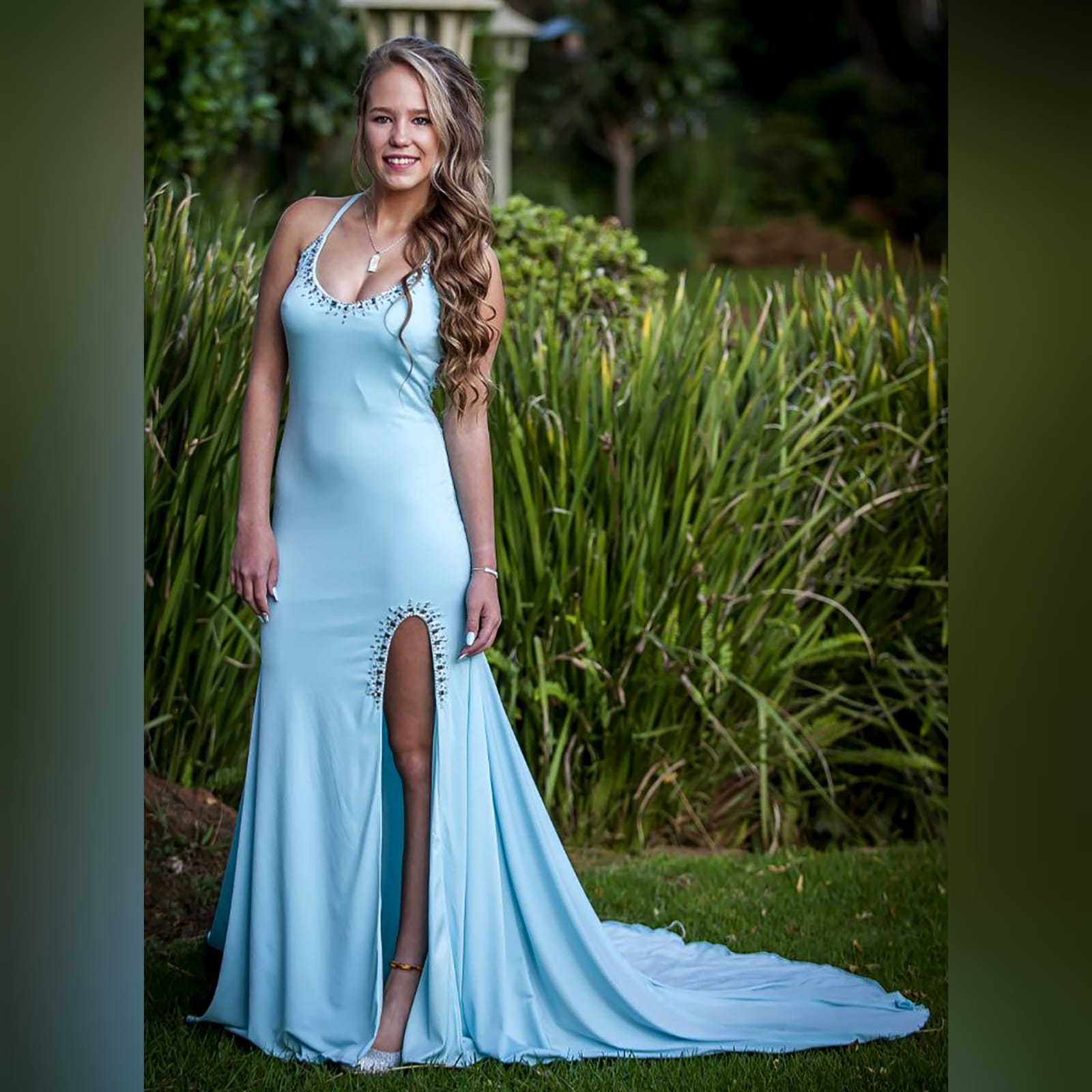 Aqua blue and silver prom dress 7 aqua blue and silver prom dress with a rounded neckline, open low v back with thin crossed straps, slit and a train. Dress detailed with silver beads and stones.