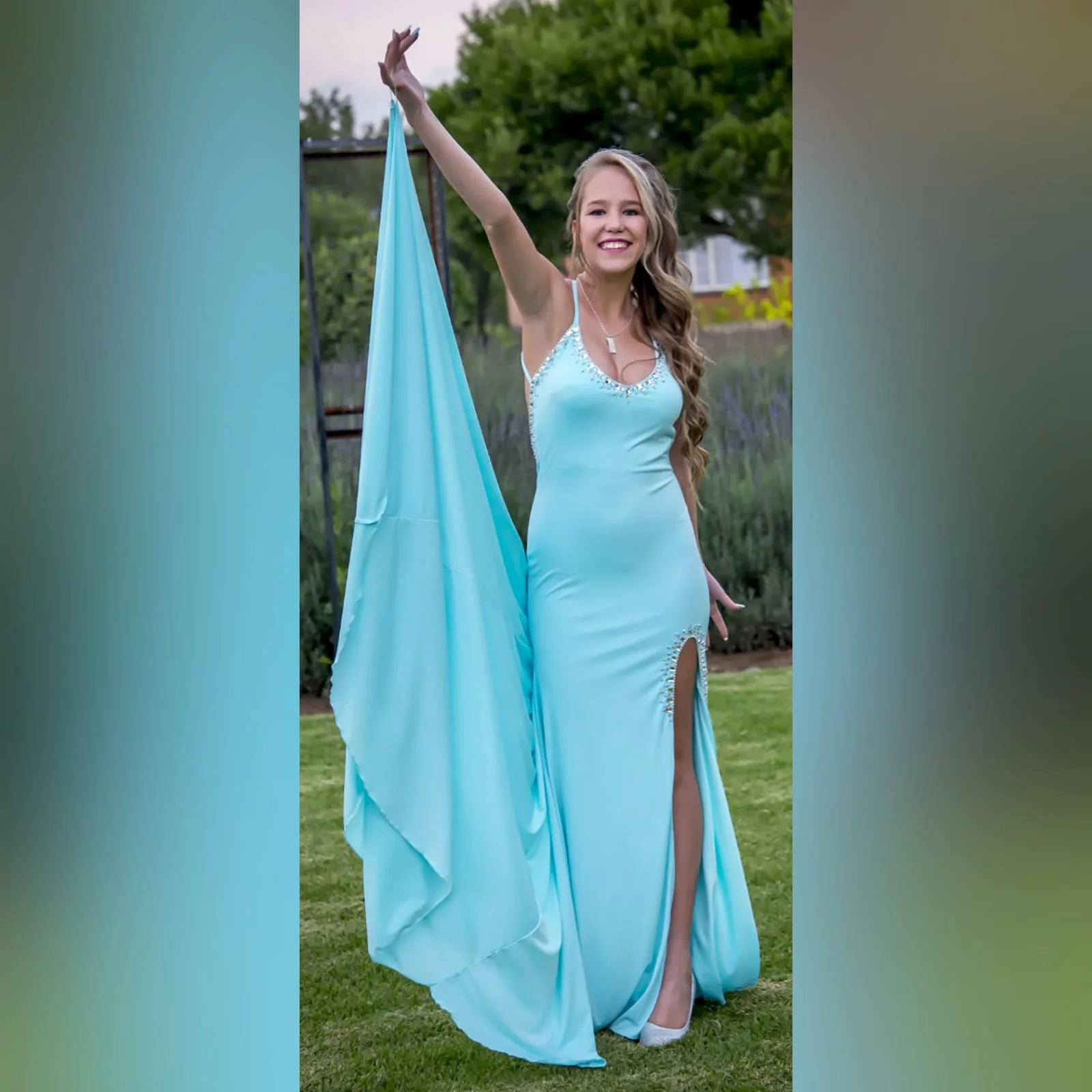 Aqua blue and silver prom dress 1 aqua blue and silver prom dress with a rounded neckline, open low v back with thin crossed straps, slit and a train. Dress detailed with silver beads and stones.