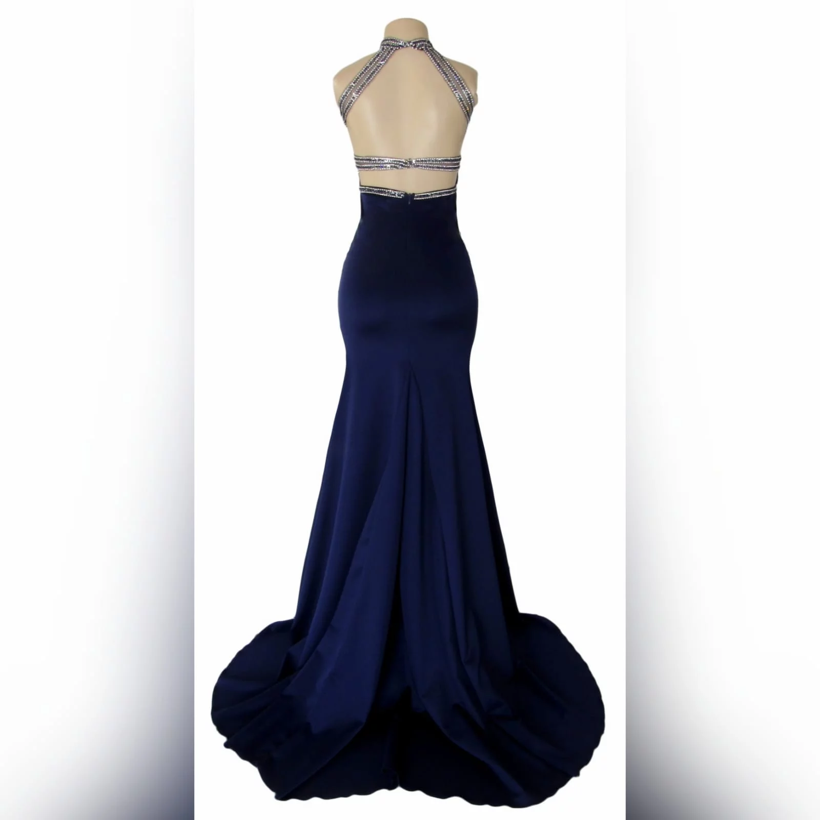 Navy blue silver beaded prom dress 2 navy blue silver beaded prom dress with an illusion neckline and a choker effect. Backless design detailed with beaded straps. Fitted bottom with a slit and a train.