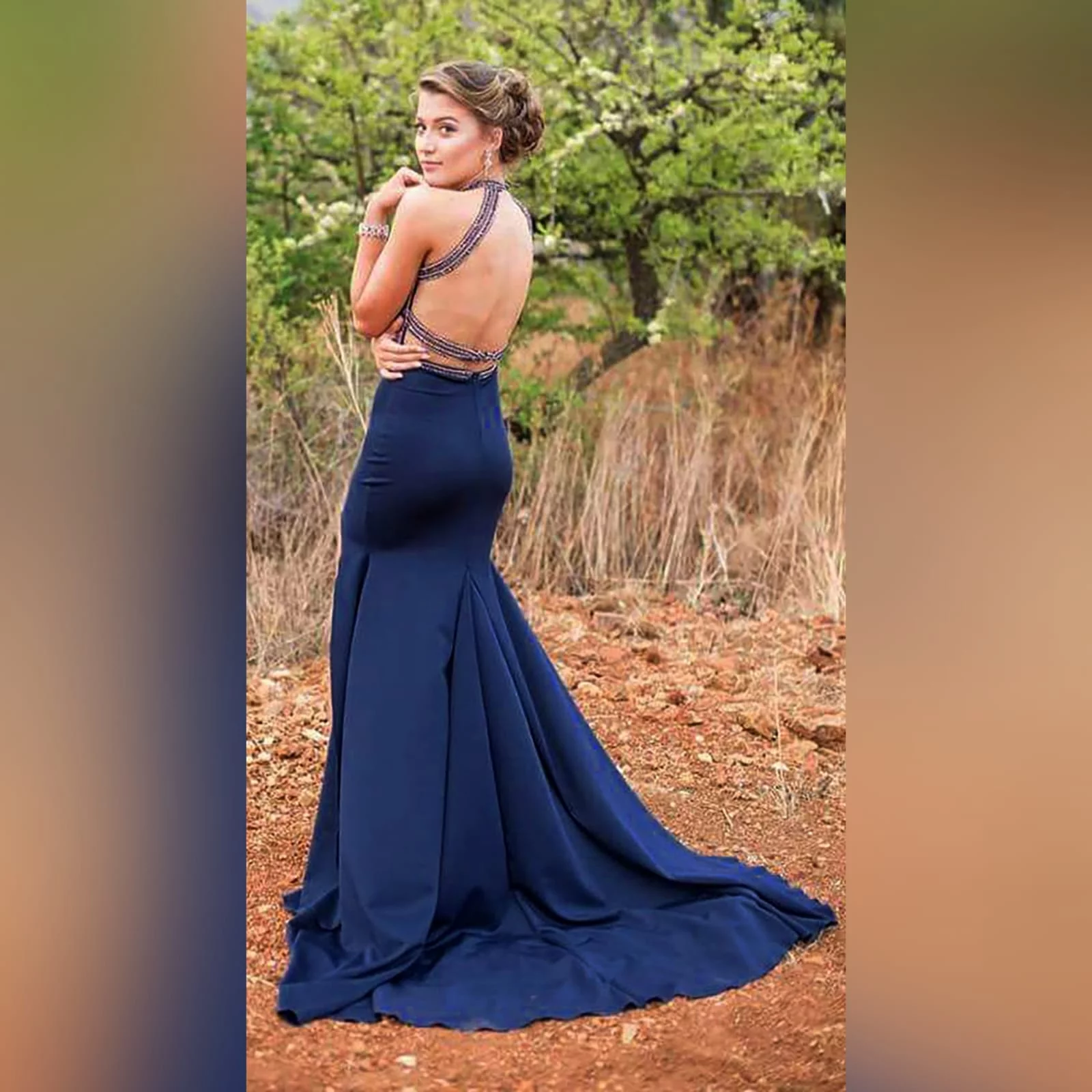 Navy blue silver beaded prom dress 6 navy blue silver beaded prom dress with an illusion neckline and a choker effect. Backless design detailed with beaded straps. Fitted bottom with a slit and a train.