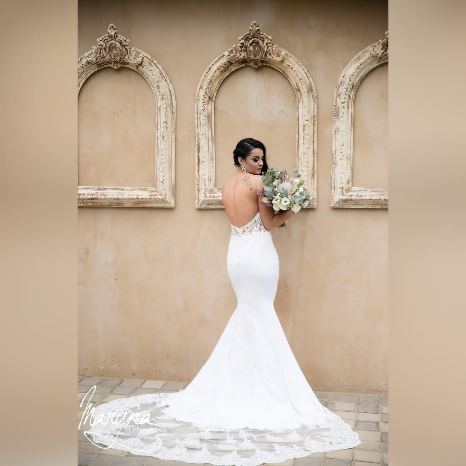 White lace mermaid wedding dress with lace train 3 white lace mermaid wedding dress, lace bodice with a v neckline, low open back and thin shoulder straps detailed with diamante. Lace from the waist down, creating a long sheer lace train. With a train hookup and a matching garter.