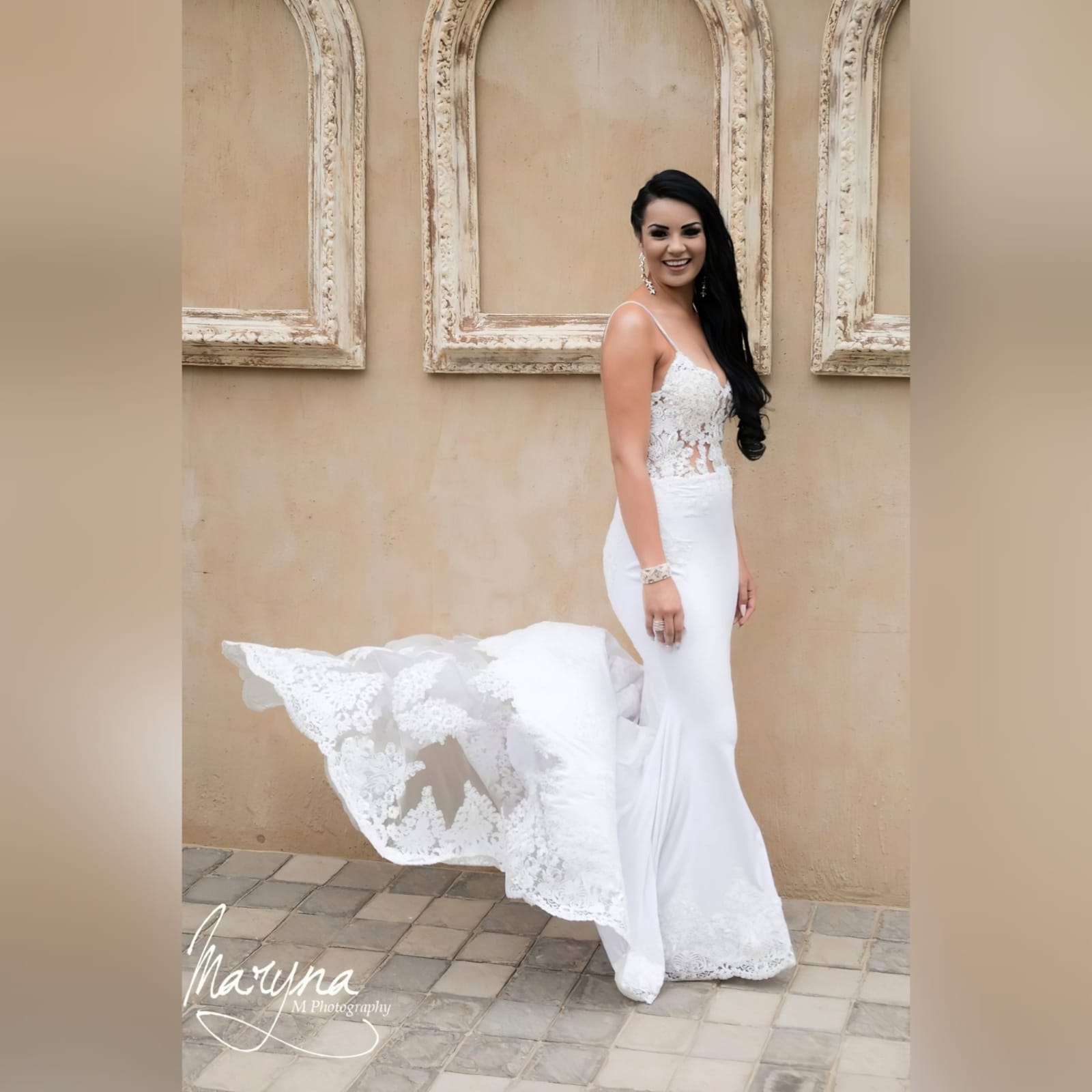 White lace mermaid wedding dress with lace train 8 white lace mermaid wedding dress, lace bodice with a v neckline, low open back and thin shoulder straps detailed with diamante. Lace from the waist down, creating a long sheer lace train. With a train hookup and a matching garter.