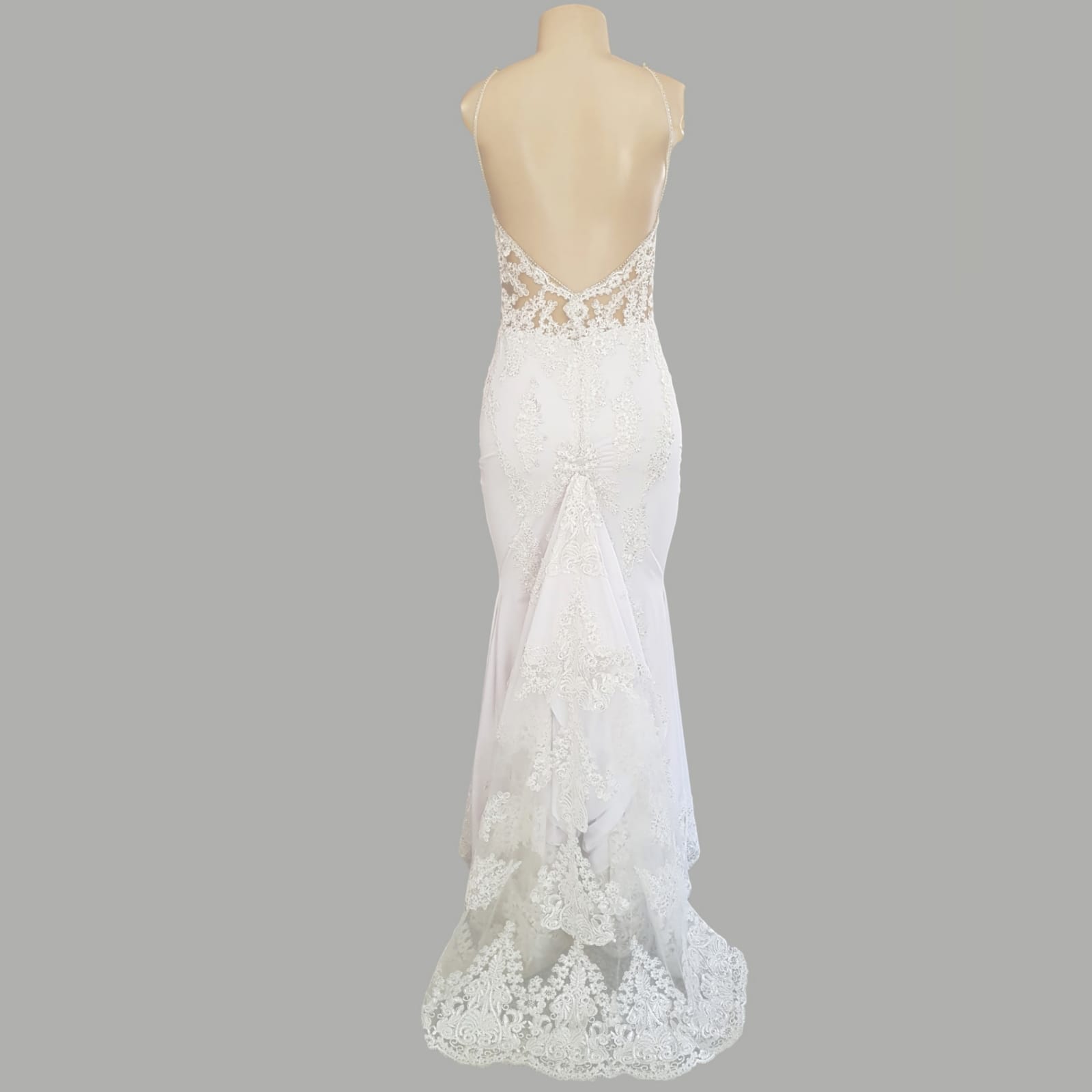 White lace mermaid wedding dress with lace train 11 white lace mermaid wedding dress, lace bodice with a v neckline, low open back and thin shoulder straps detailed with diamante. Lace from the waist down, creating a long sheer lace train. With a train hookup and a matching garter.