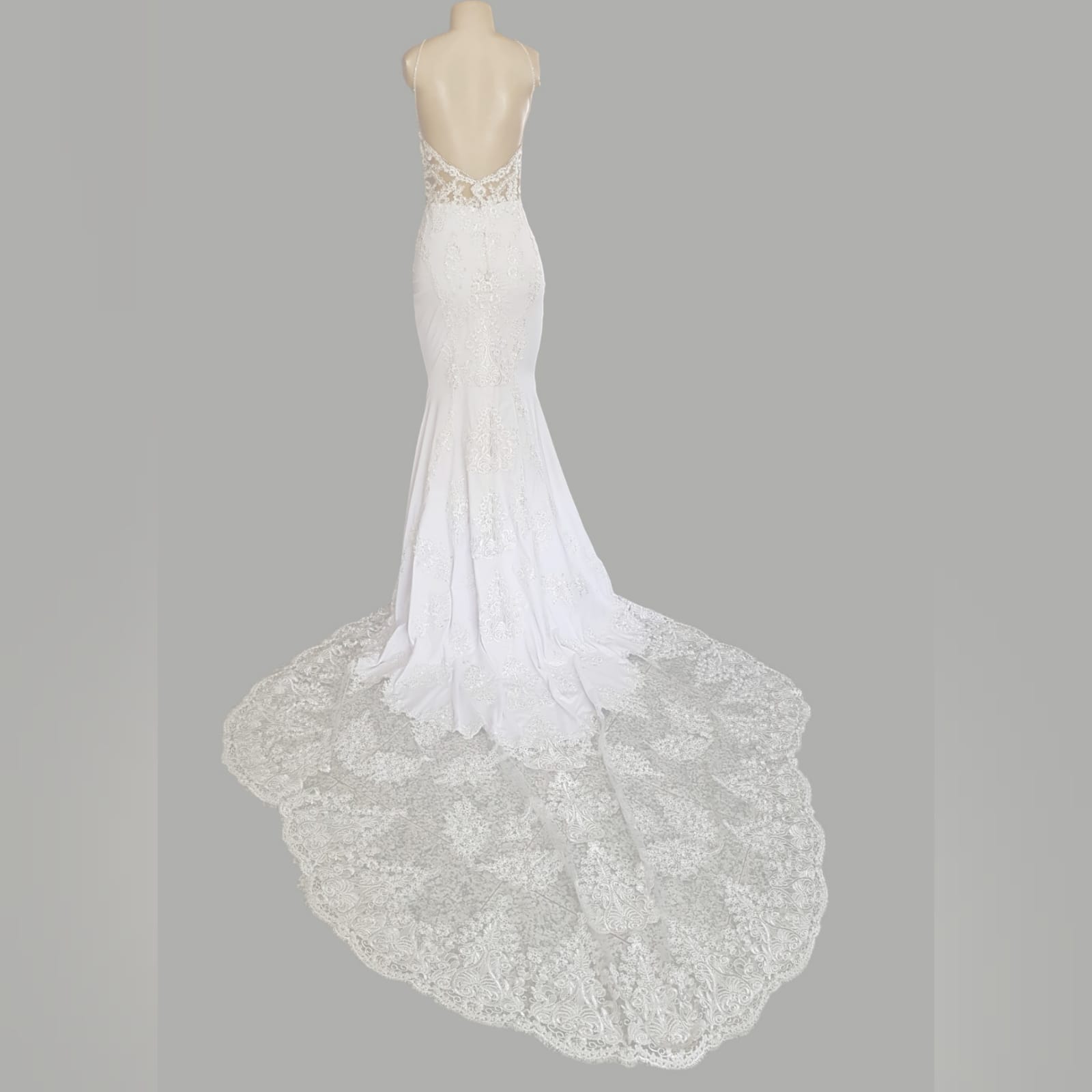 White lace mermaid wedding dress with lace train 13 white lace mermaid wedding dress, lace bodice with a v neckline, low open back and thin shoulder straps detailed with diamante. Lace from the waist down, creating a long sheer lace train. With a train hookup and a matching garter.