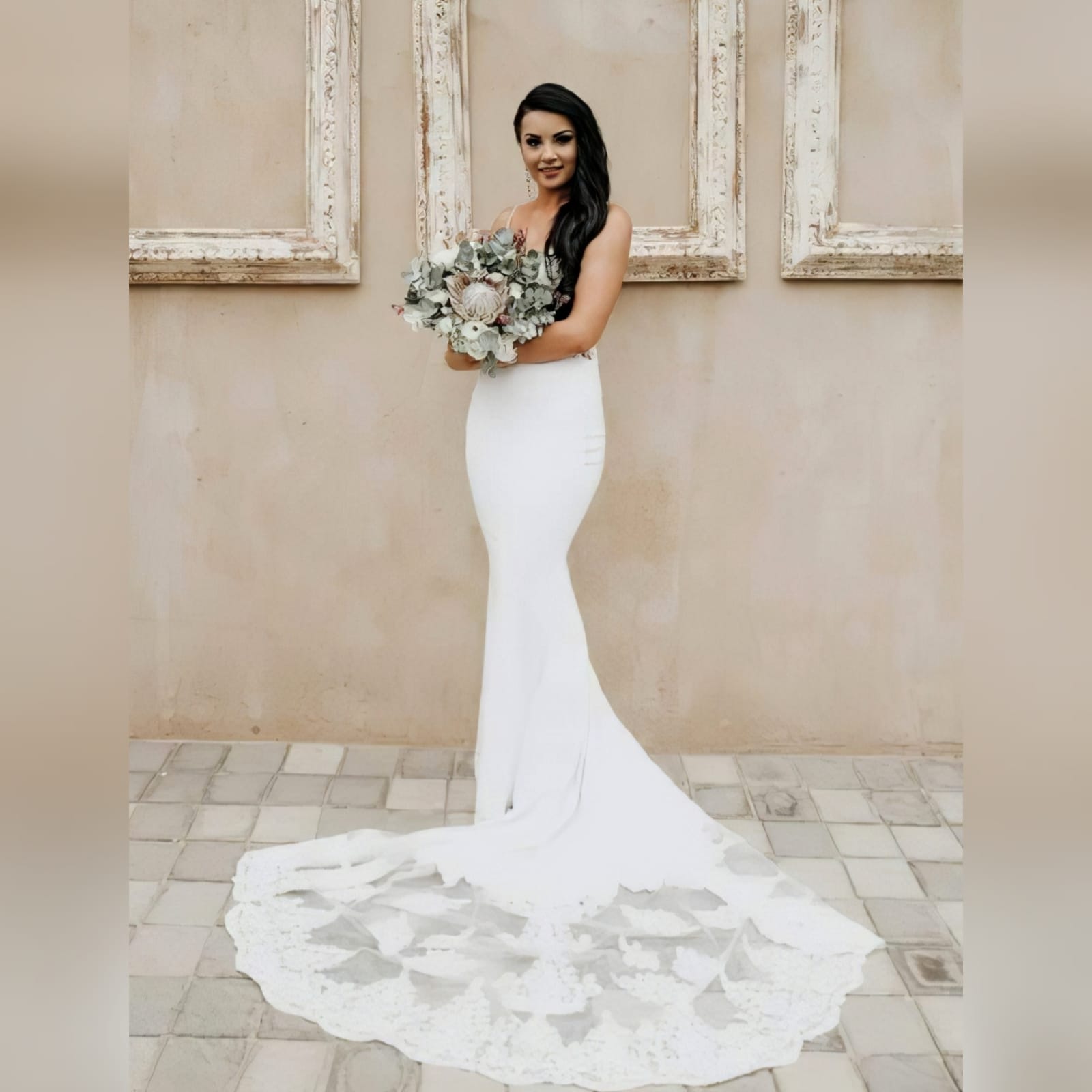White lace mermaid wedding dress with lace train 2 white lace mermaid wedding dress, lace bodice with a v neckline, low open back and thin shoulder straps detailed with diamante. Lace from the waist down, creating a long sheer lace train. With a train hookup and a matching garter.