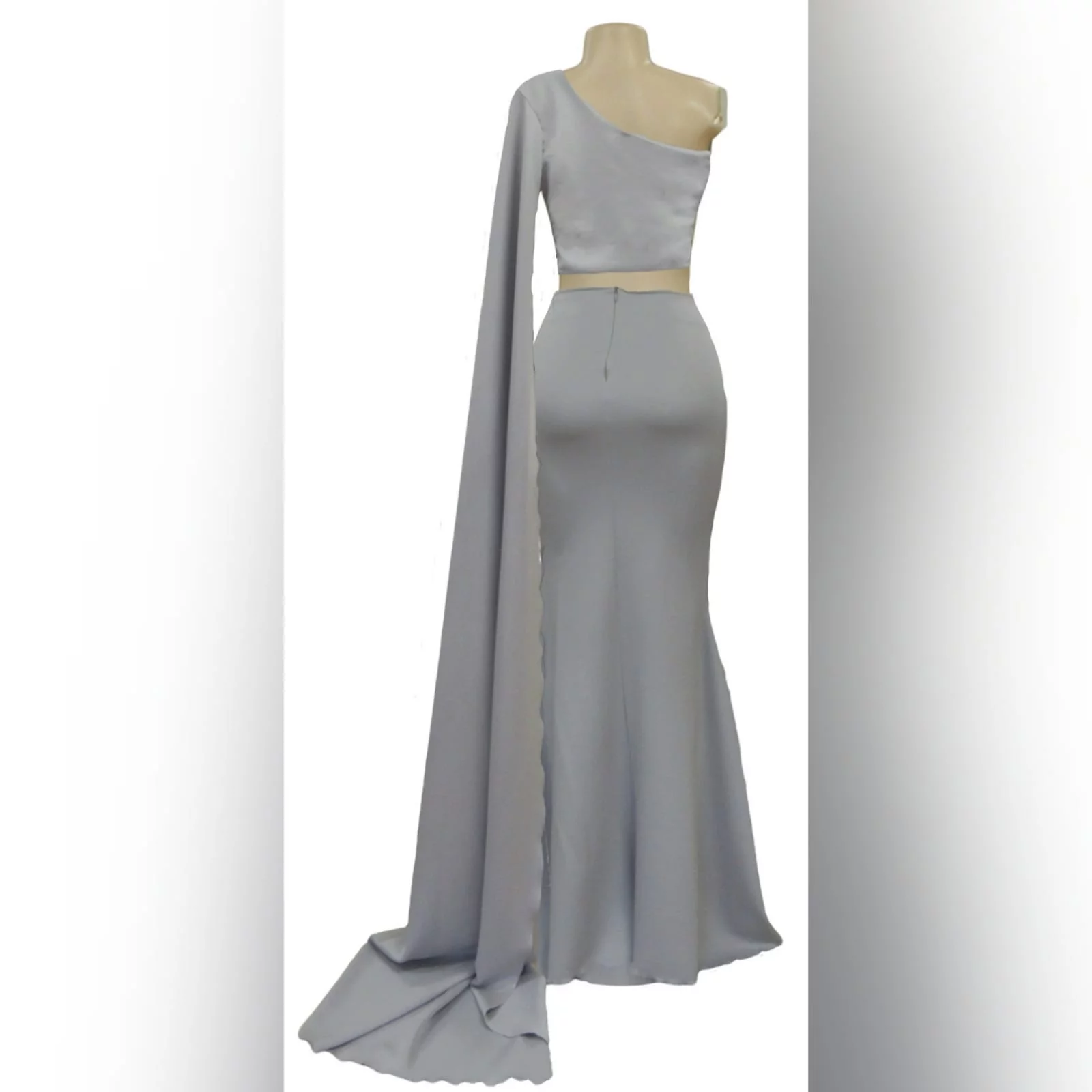 2 piece light grey matric dance dress 5 2 piece light grey matric dance dress, crop top with a single shoulder and a long wide sleeve creating a train. With a fitted long skirt, with a high slit.