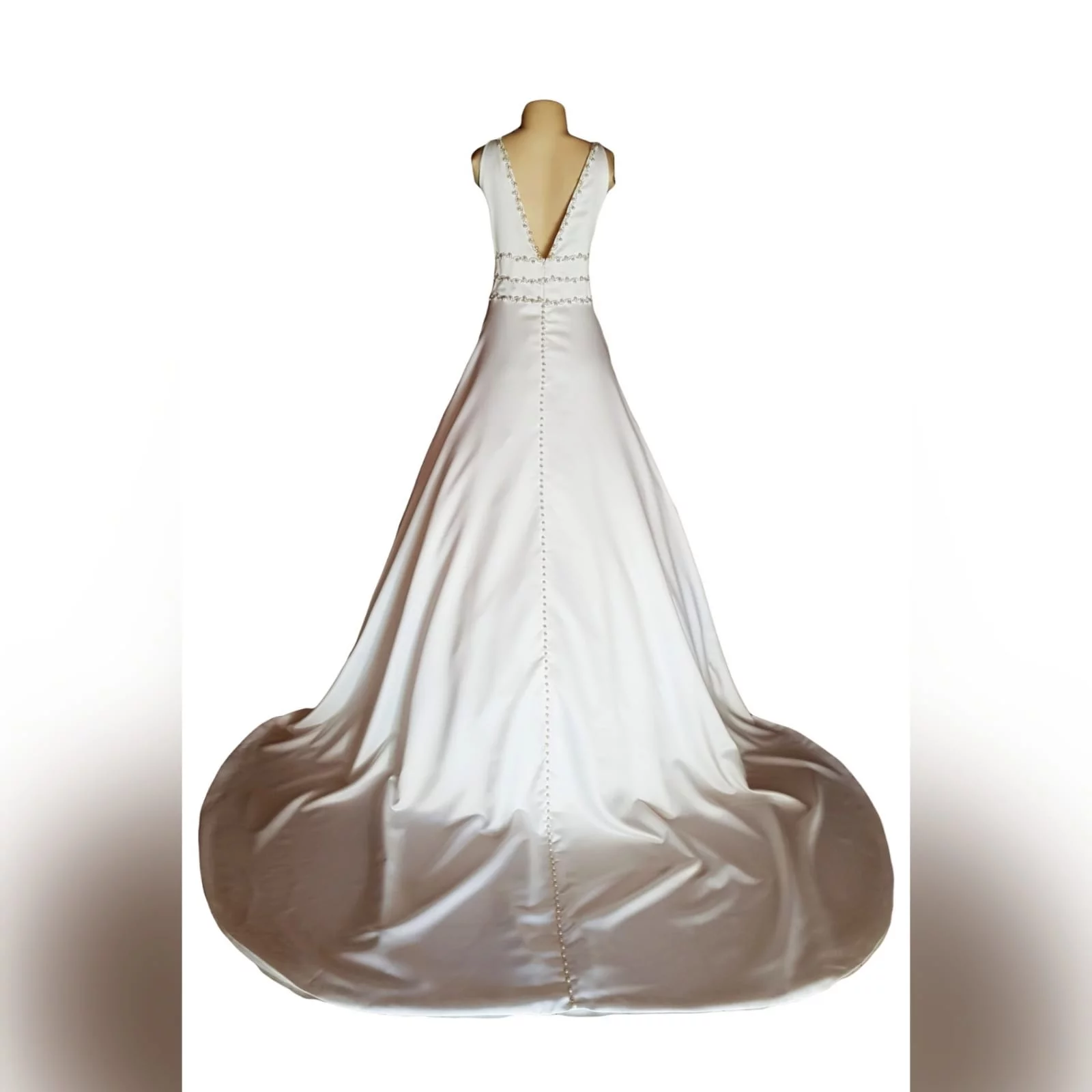 A line brides dress in a pearl satin fabric 17 this elegant wedding dress was designed and made for a wedding in brazil an a-line brides dress in a pearl satin fabric, with an illusion deep neckline and v open back. Detailed with diamante, pearls and buttons. A wide train that hooks up. And a brazilian traditional embroidered inside hem with the bridesmaid's names.