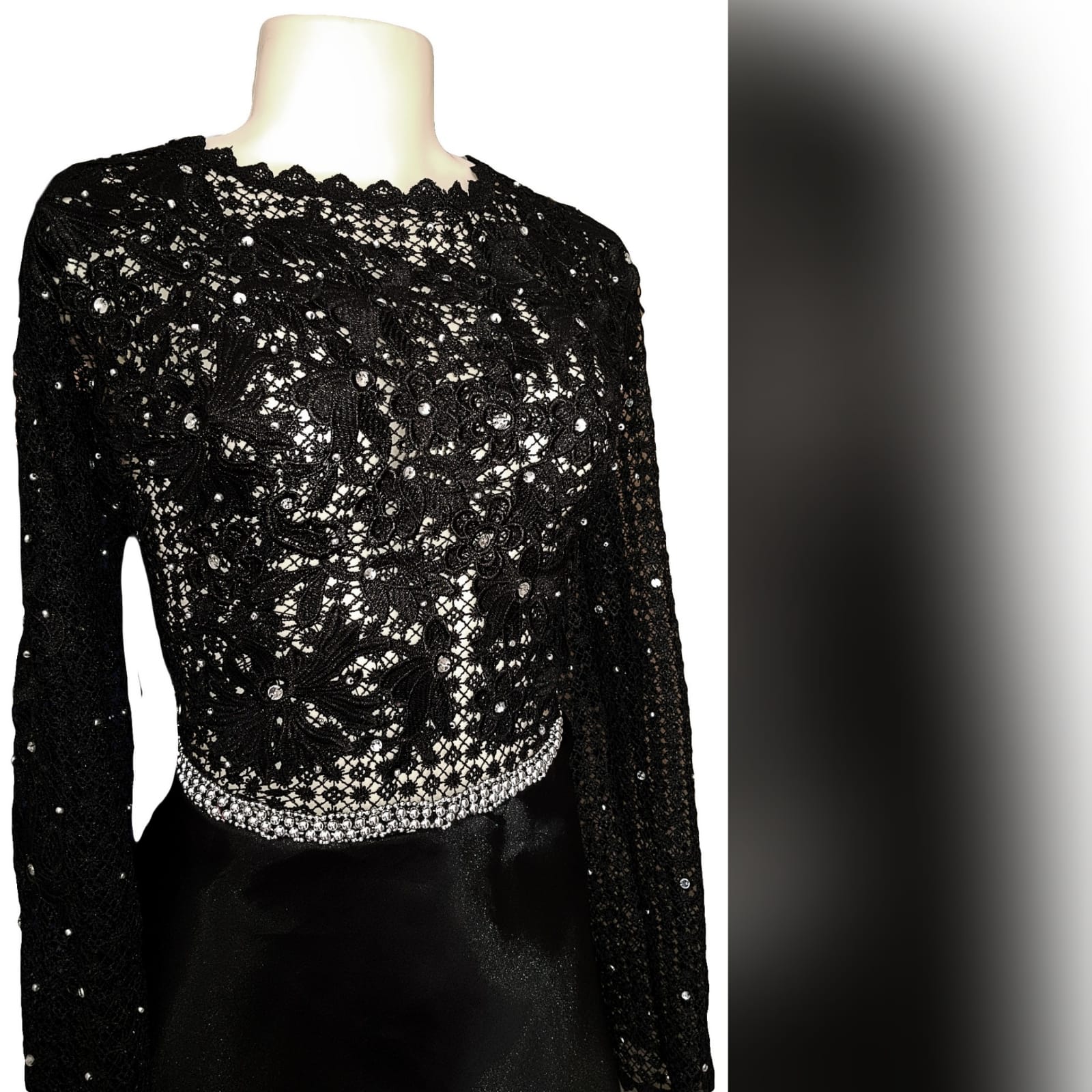 Black prom dress with a lace bodice 4 an elegant design created for a prom night. Black prom dress with a lace bodice with a slight sheer look detailed with silver beads and waist belt. Round neckline and long sleeves bottom flowy in a bridal organza