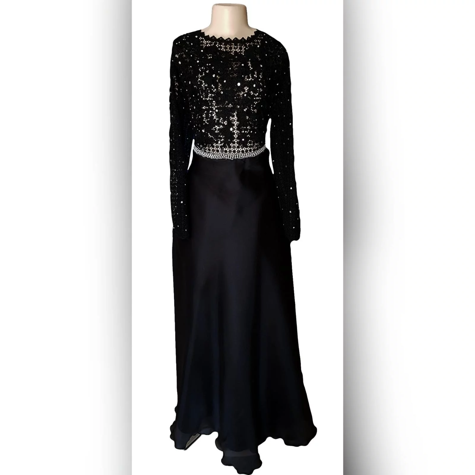 Black prom dress with a lace bodice 8 an elegant design created for a prom night. Black prom dress with a lace bodice with a slight sheer look detailed with silver beads and waist belt. Round neckline and long sleeves bottom flowy in a bridal organza