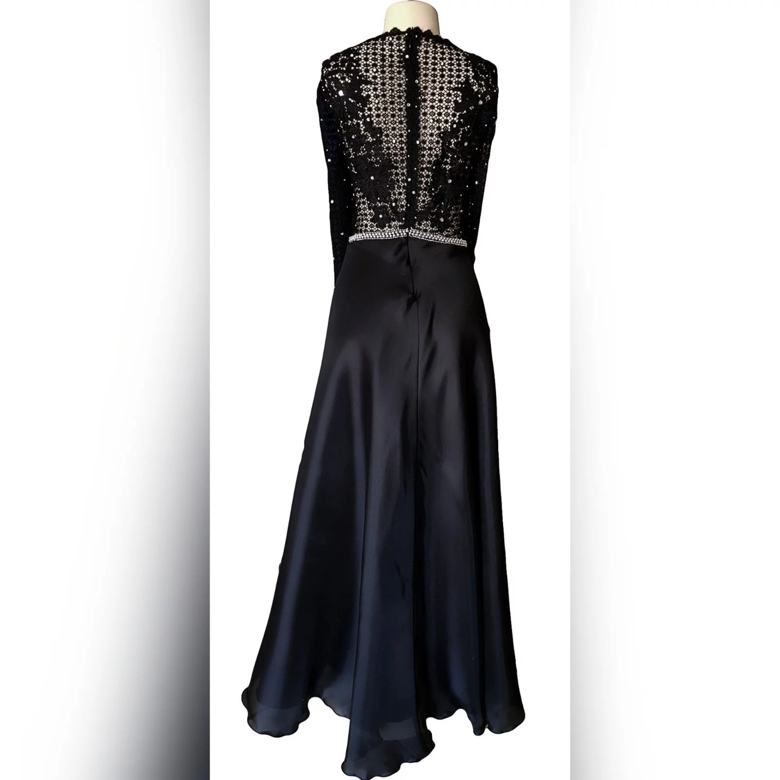 Black prom dress with a lace bodice 9 an elegant design created for a prom night. Black prom dress with a lace bodice with a slight sheer look detailed with silver beads and waist belt. Round neckline and long sleeves bottom flowy in a bridal organza